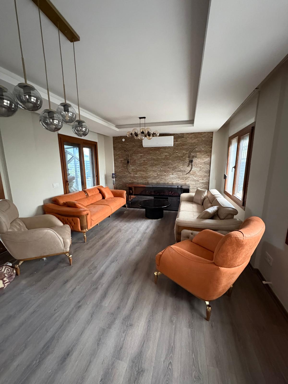 Modern orange and beige sofa set for stylish living. Comfortable seating group with elegant wooden details. Explore Inegol furniture campaigns.