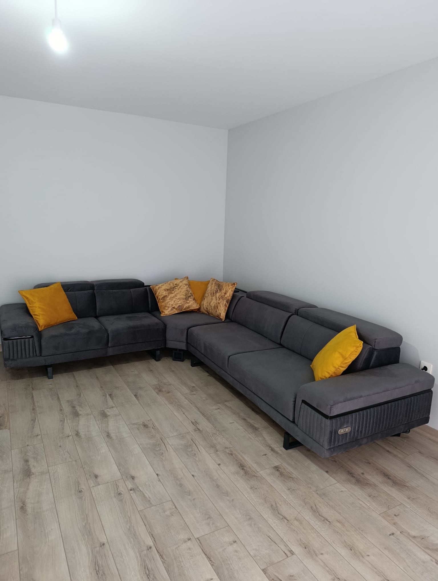 Comfortable and stylish anthracite gray L-shaped sectional sofa with yellow and patterned throw pillows, reflecting Modern Inegol furniture design.