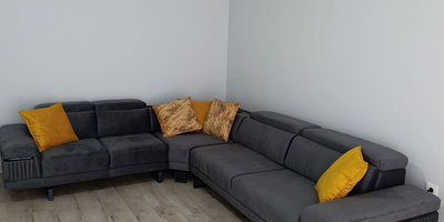 Rahat ve şık füme gri L köşe koltuk takımı, sarı ve desenli yastık detaylarıyla Modern inegol mobilya tarzını yansıtır. Oturma odası için ideal.