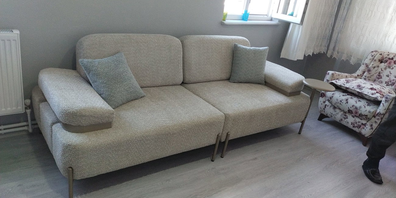 Açık gri/bej modern kanepeler ve çiçek desenli berjerlerden oluşan salon takımı, metal ayaklar ve ahşap detaylarla tamamlandı. İnegöl mobilya Fiyatları kalitesiyle.