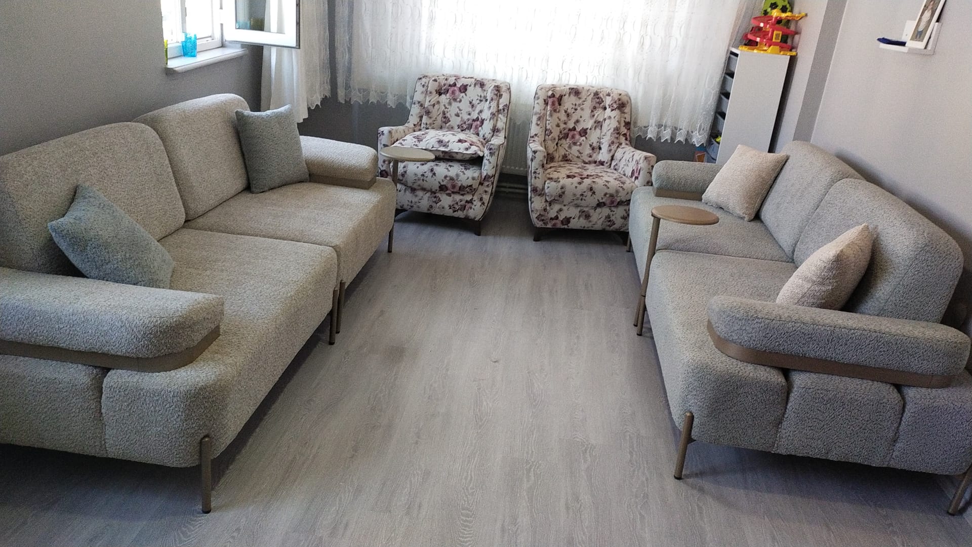 Elegant living room set featuring light grey/beige modern sofas and floral patterned armchairs with metal legs and wood details. Discover Inegol furniture prices.