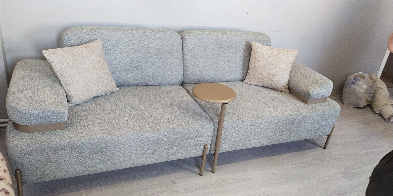 Açık gri/bej modern kanepeler ve çiçek desenli berjerlerden oluşan salon takımı, metal ayaklar ve ahşap detaylarla tamamlandı. İnegöl mobilya Fiyatları kalitesiyle.
