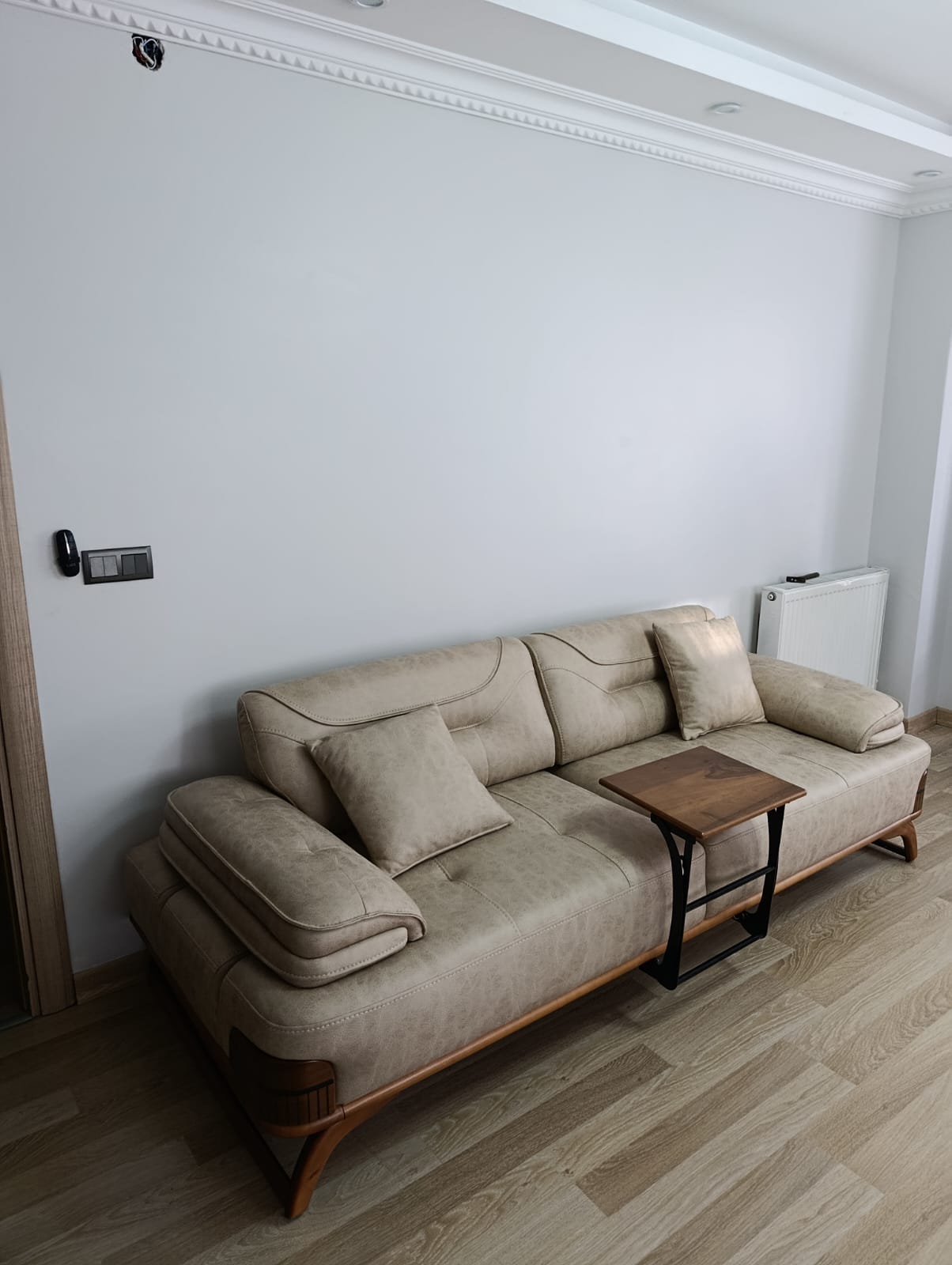 Abdullah C. 2026 beige modern sofa with wooden details and a functional side table. A quality Inegol furniture product for comfort.
