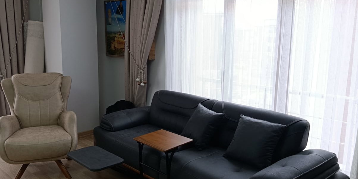 Abdullah C. 2026 bej rengi modern kanepe, ahşap detayları ve fonksiyonel yan sehpasıyla. Bu kaliteli İnegöl mobilyası konfor sunuyor.