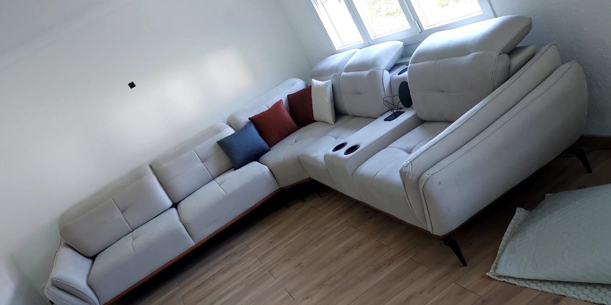 Light grey modern L-shaped corner sofa with cup holders and adjustable backrest offers ultimate comfort. Discover affordable Inegol furniture prices.