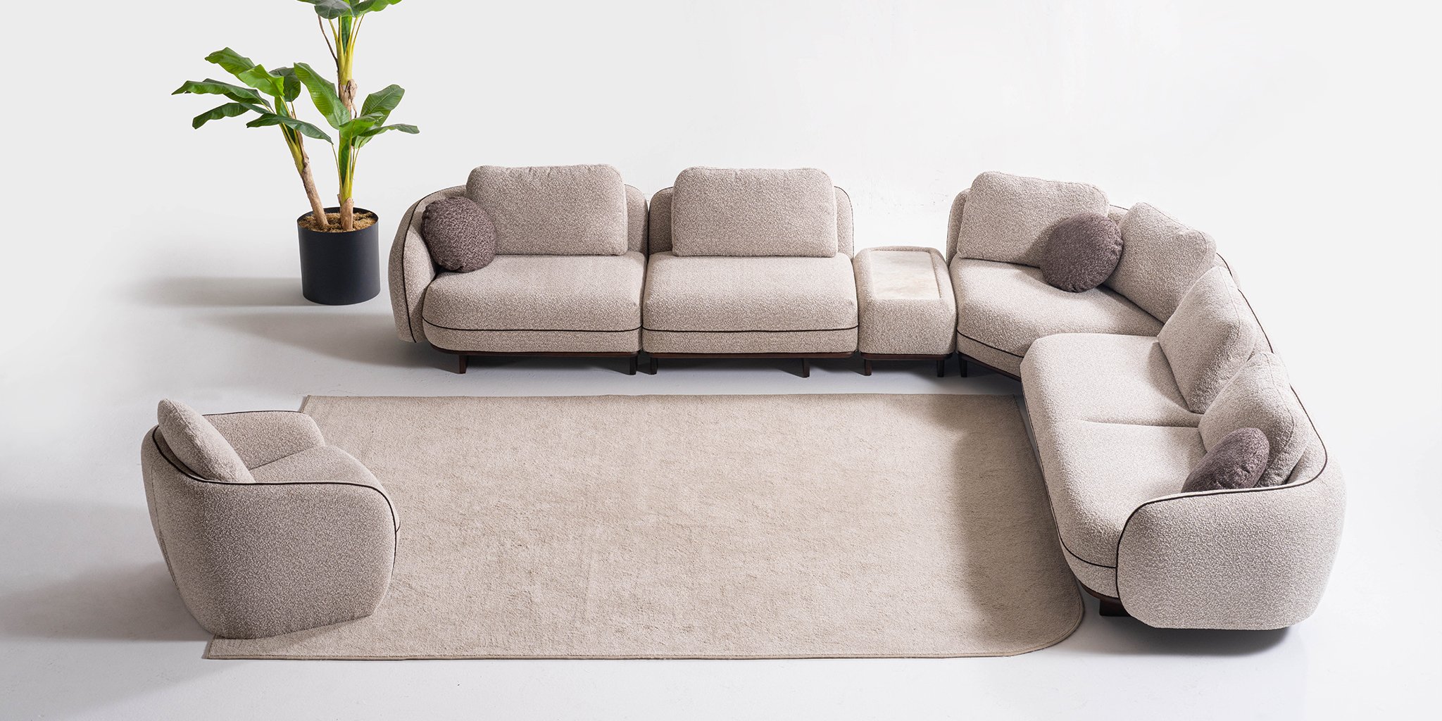 Modern Artra corner sofa set with cream boucle fabric, elegant wooden base details, and rounded lines. A clear representation of quality Inegol furniture.