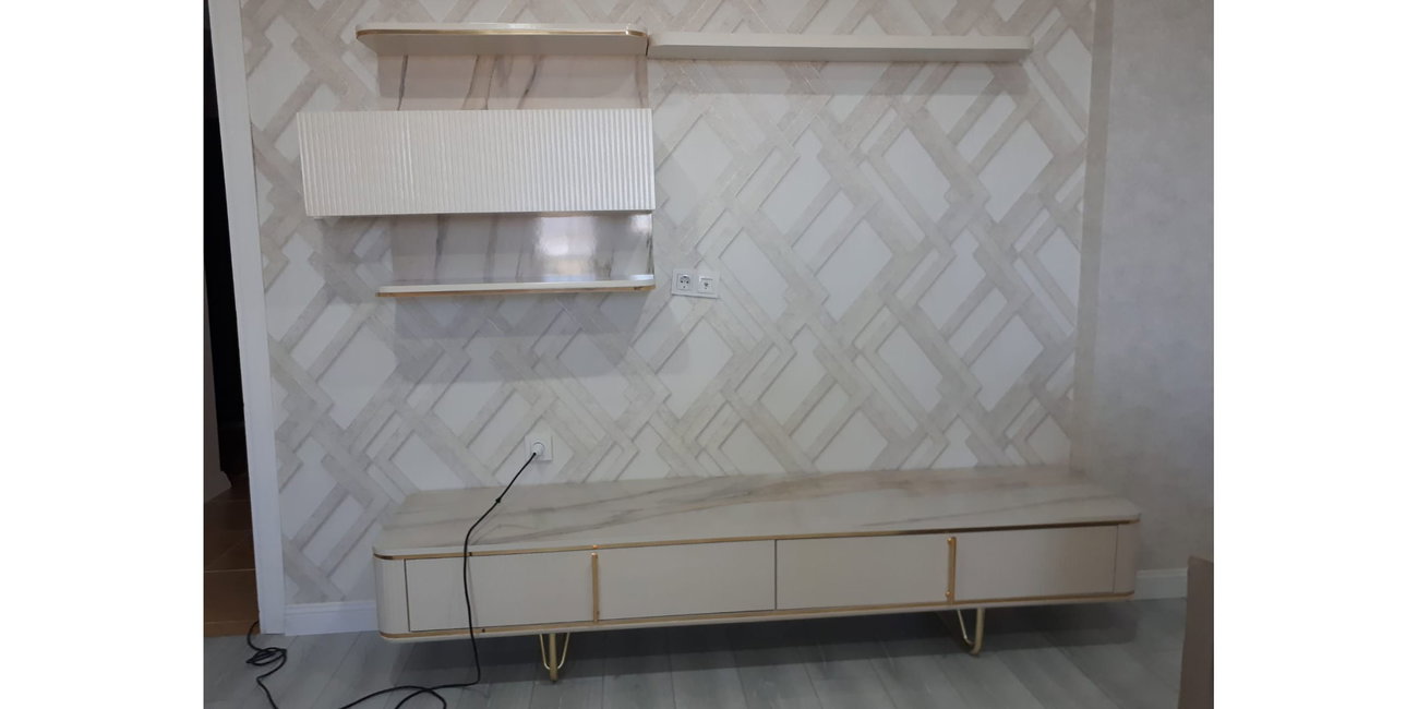 Mermer desenli beyaz TV ünitesi ve duvara monte raflar, zarif gold detaylarla modern bir görünüm sunuyor. Şık ve fonksiyonel bu İnegöl mobilyası, oturma odalarına estetik katarak yaşam alanınızı dönüştürür.