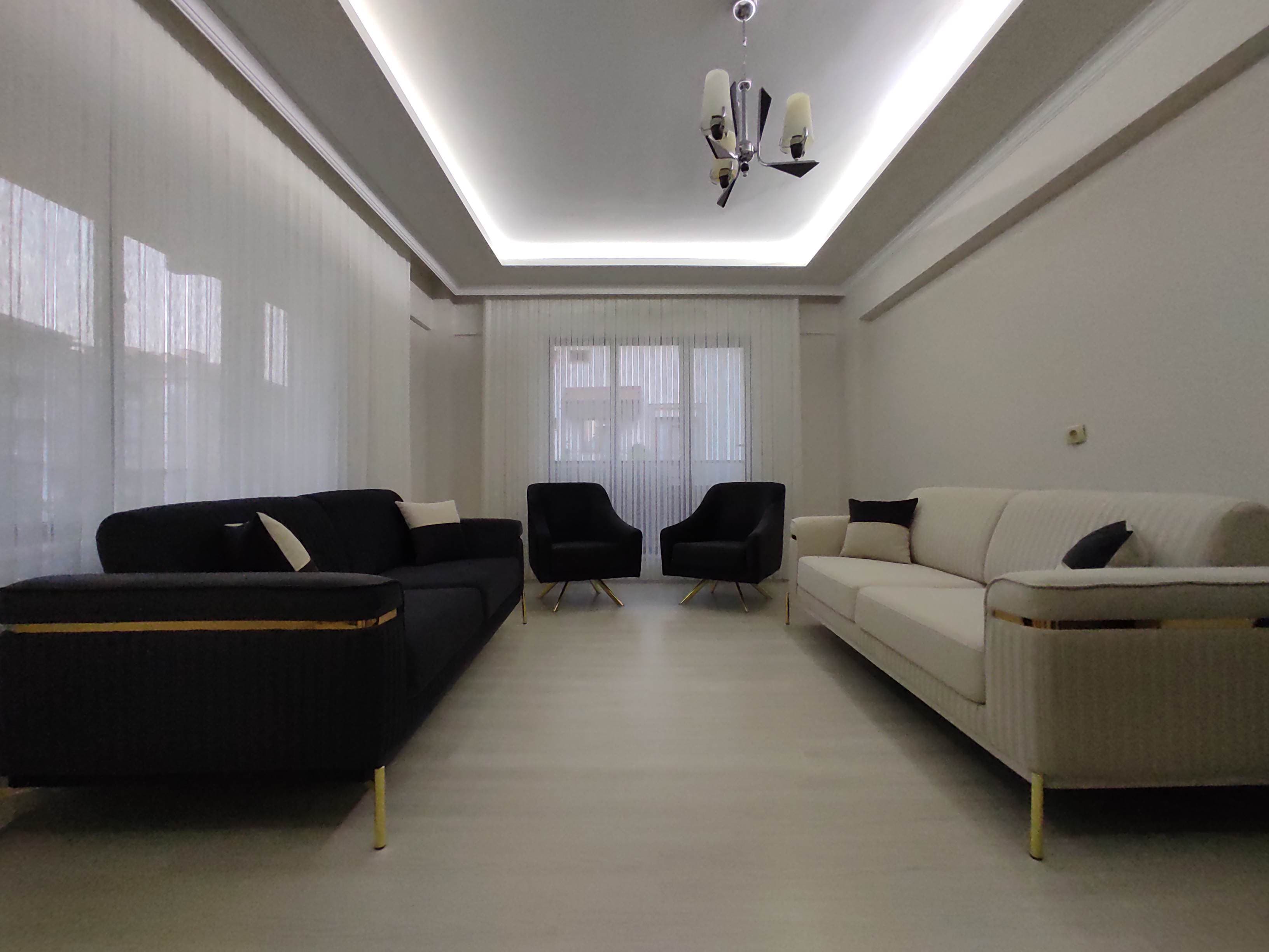 Modern Aynur Gezici living room set featuring black and cream sofas, armchairs with gold accents. Affordable Inegol furniture elegance.