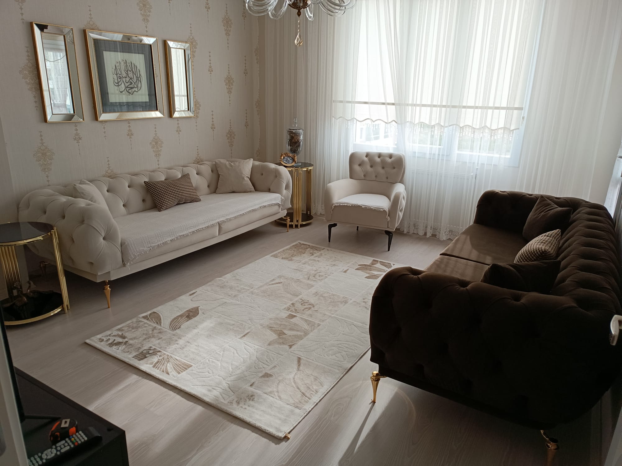 Modern and classic living room set with cream and brown Chesterfield sofas and a patterned rug. Ideal for Inegol furniture campaigns.