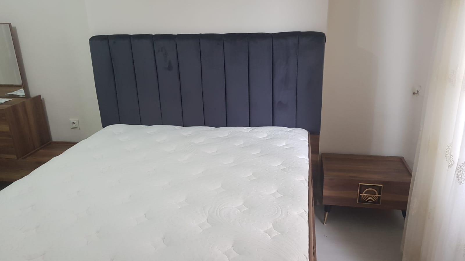 Stylish Canan Özdoğan - Bingöl bedroom featuring a modern dark gray velvet upholstered bed and wooden nightstand. Check Inegol furniture prices.