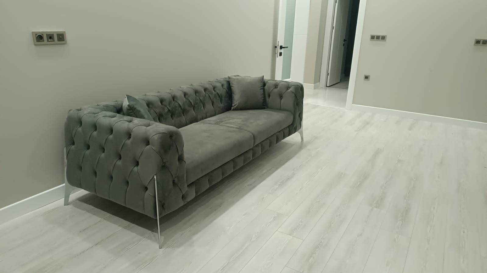 Elegant grey velvet chesterfield sofa with tufted details and sleek metal legs, a prime example of Bursa furniture.