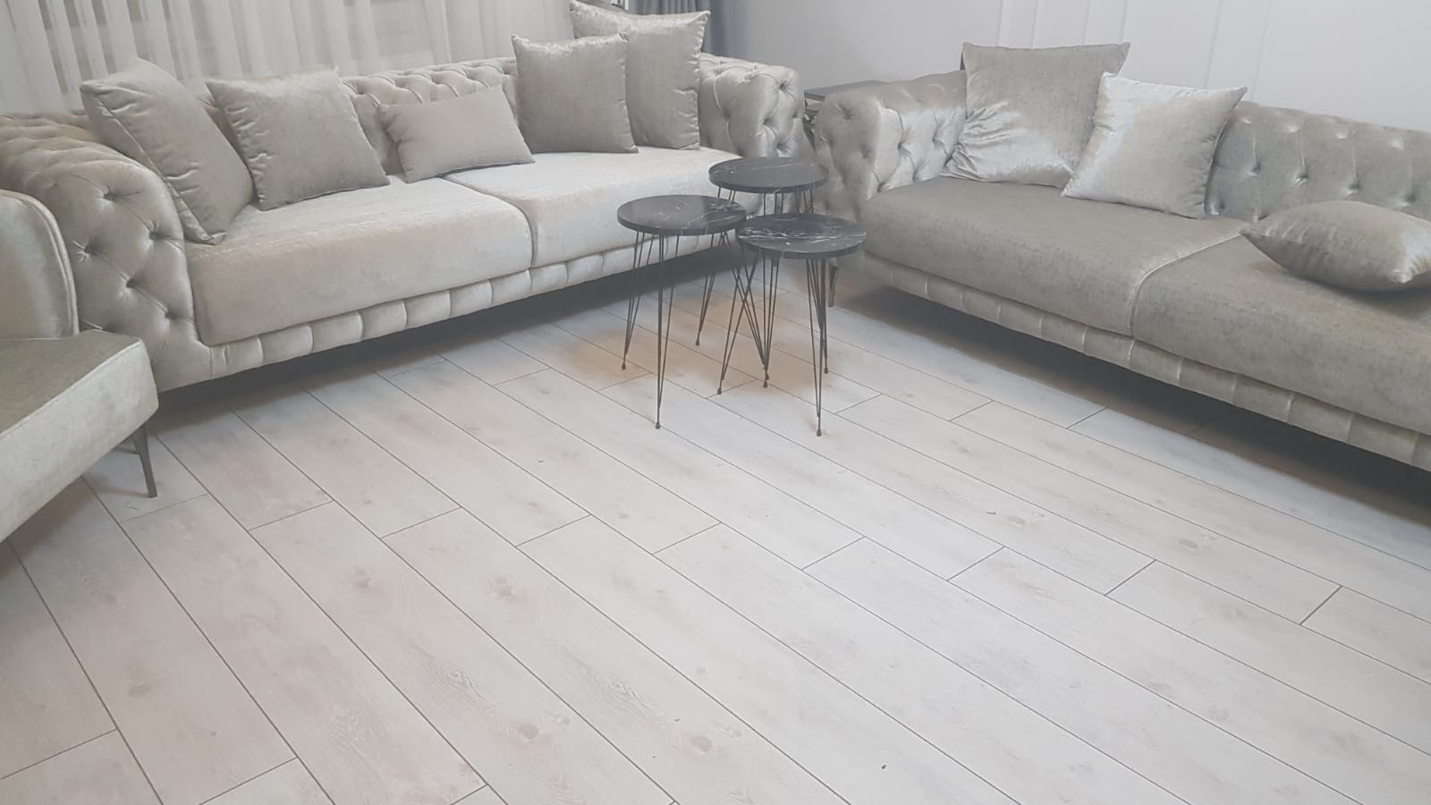 Light-colored Chesterfield sofa set with three marble pattern nesting tables. Elegant and comfortable living room decor. Inegol furniture prices.