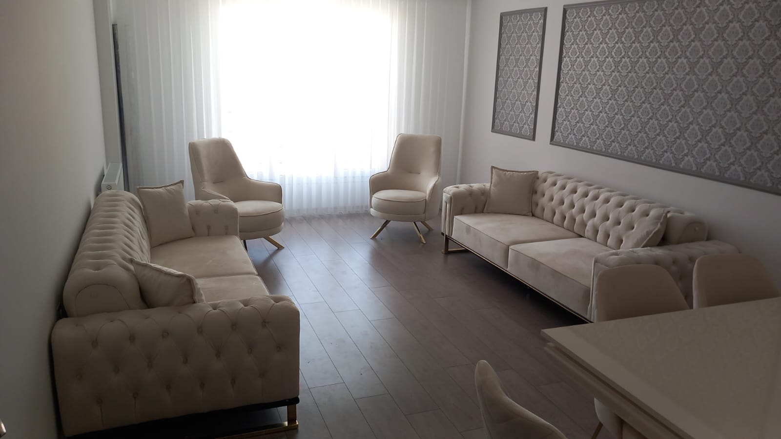 Luxurious cream velvet Chesterfield sofa set and matching armchairs with golden accents, showcasing modern inegol furniture.
