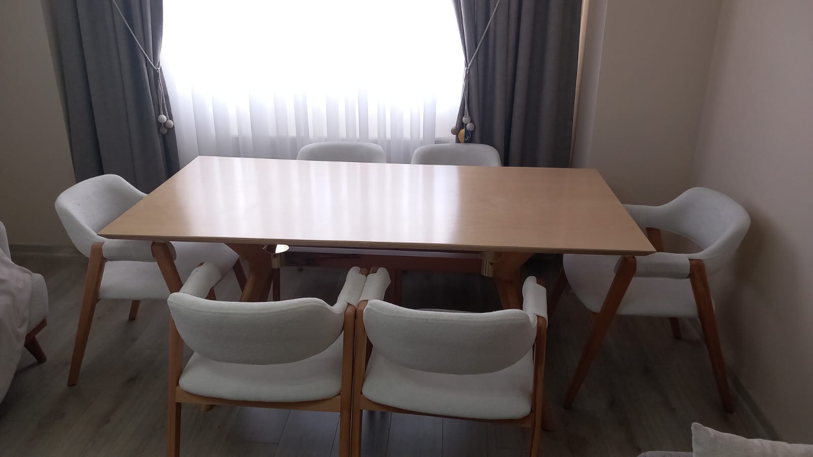 Modern dining set featuring a light wood table and white upholstered chairs. A quality Inegol furniture design.