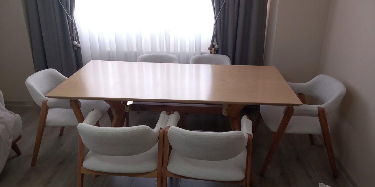 Açık renk ahşap masa ve beyaz döşemeli sandalyelerden oluşan modern yemek odası takımı. Kaliteli inegol mobilya tasarımı.