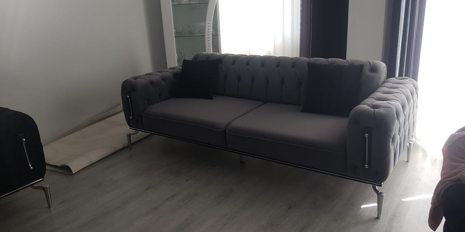 Elegant grey Chesterfield style three-seater sofa with metal legs and tufted details, reflecting Inegol furniture quality.