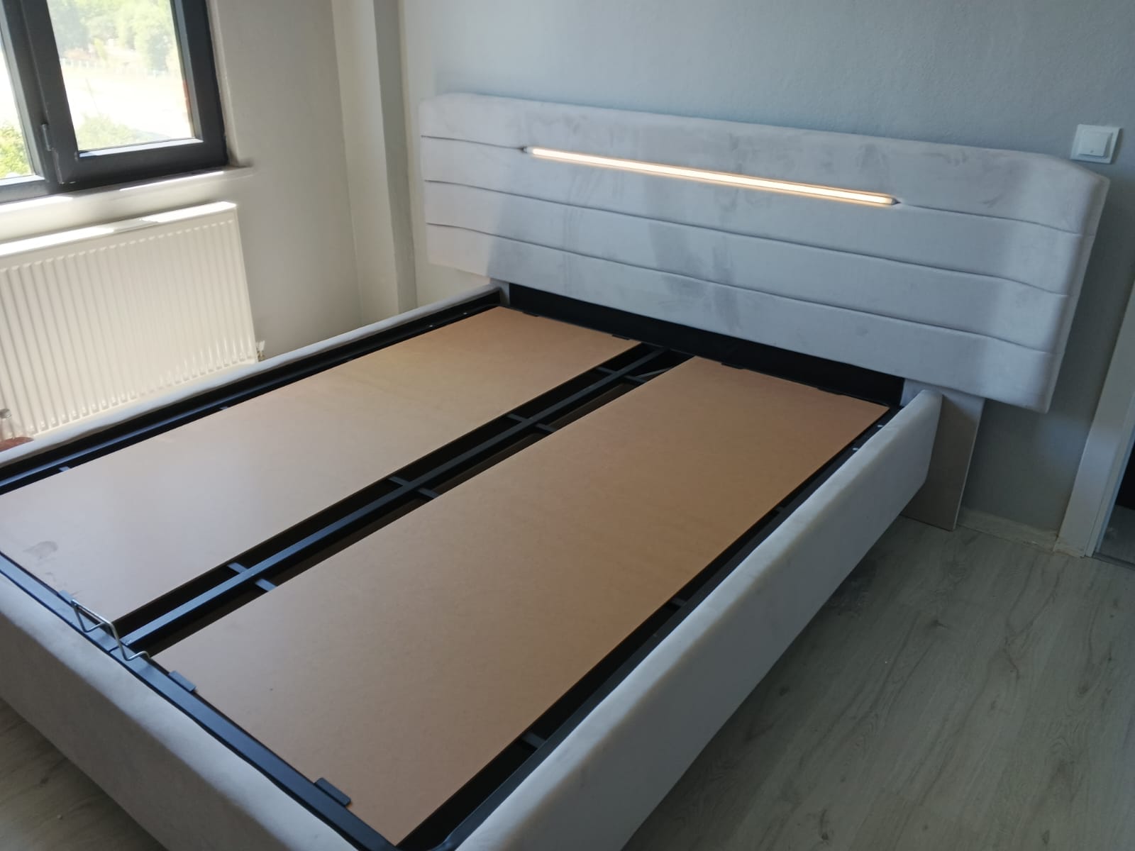 Elegant grey fabric upholstered bed base with an illuminated headboard, a prime example of Inegol furniture craftsmanship.
