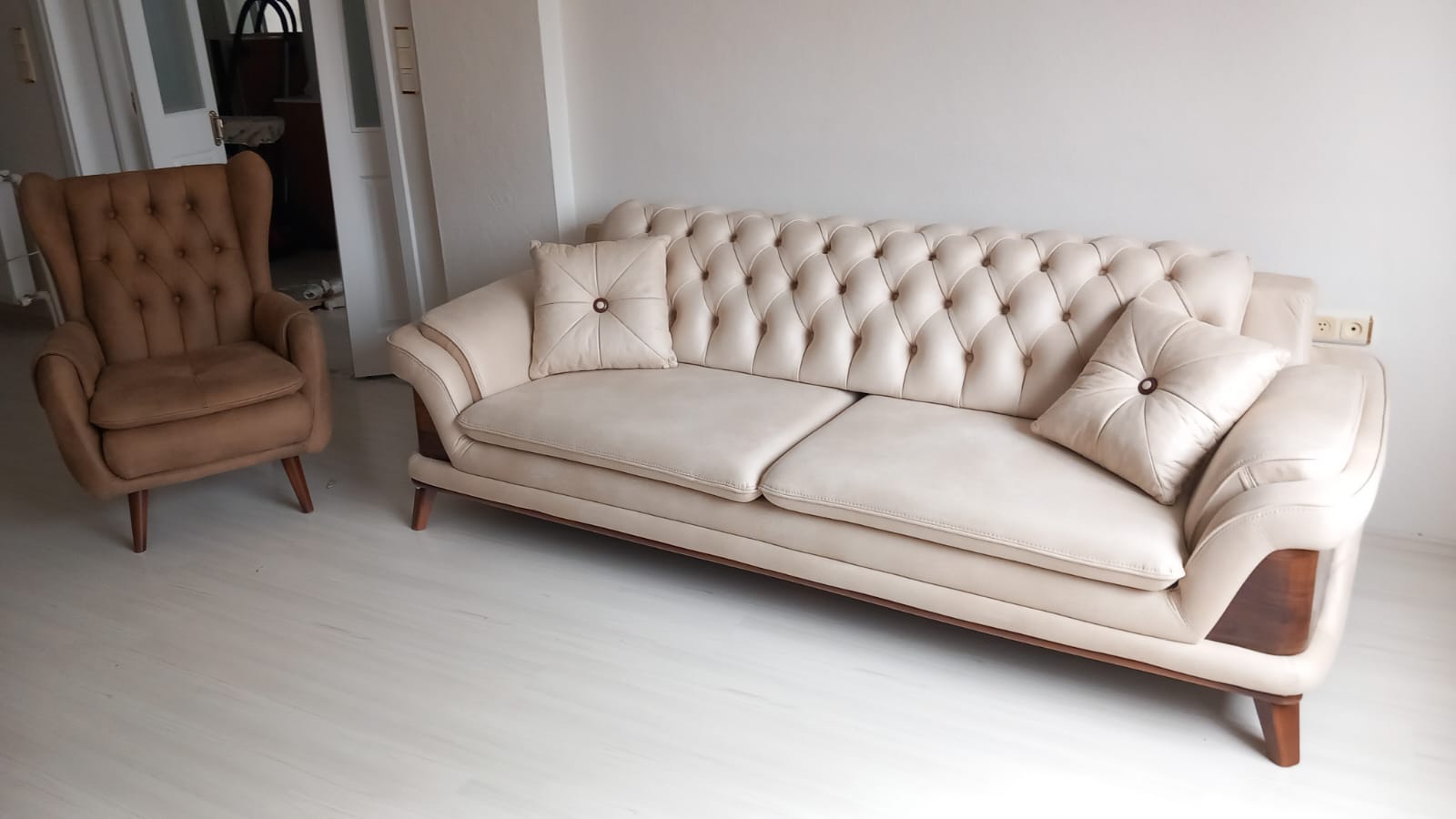 Light-colored modern chesterfield sofa set with a matching brown wingback armchair. Affordable Inegol furniture options.