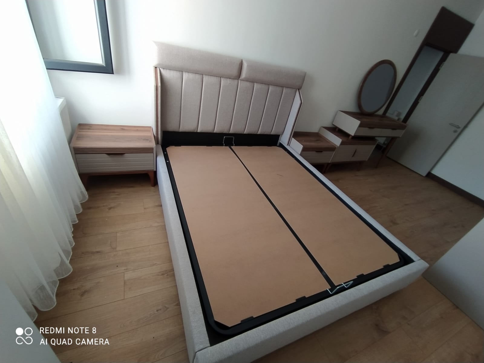 Modern cream fabric upholstered bed base, headboard, matching nightstands, and vanity, reflecting quality Inegol furniture.