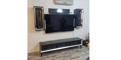 Modern mermer desenli siyah TV ünitesi, parlak yüzeyli asma dolaplar ve raf içeren şık bir salon takımı. Bu İnegöl mobilya modelleri ev dekorasyonunuza estetik katıyor.