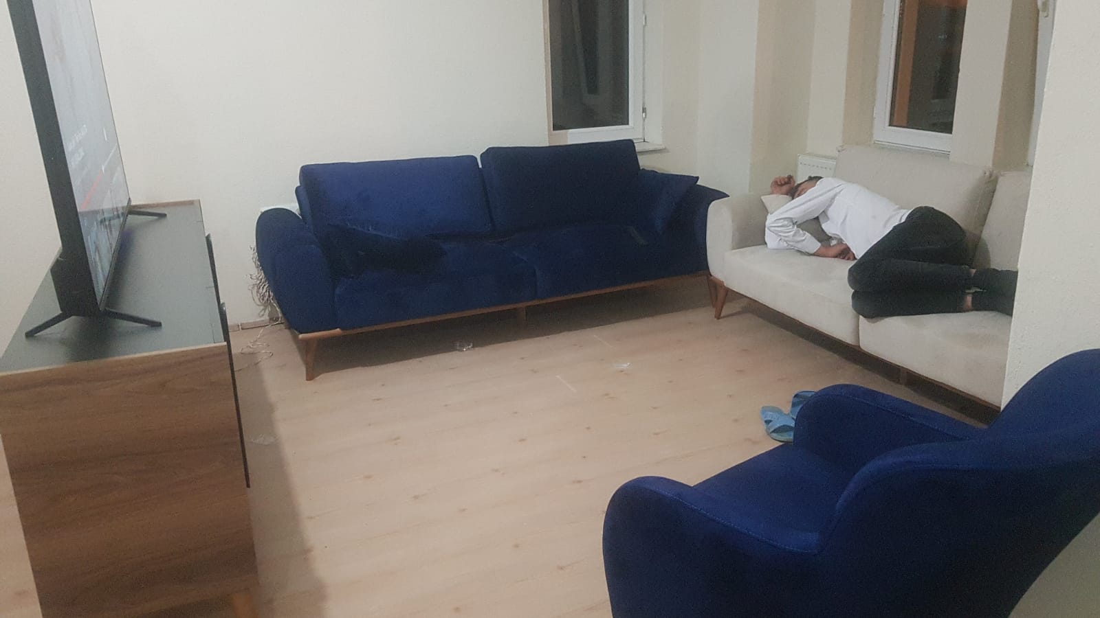 A comfortable and chic living room featuring a navy blue two-seater, a three-seater sofa, a beige sofa, and an armchair, embodying Modern Inegol furniture.