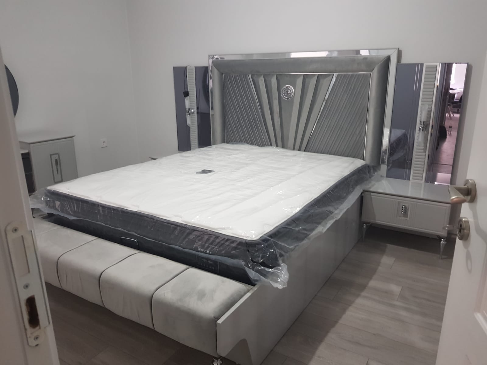 Elegant modern grey bedroom set featuring an upholstered headboard, nightstands, and a luxurious bed base. High-quality inegol furniture.