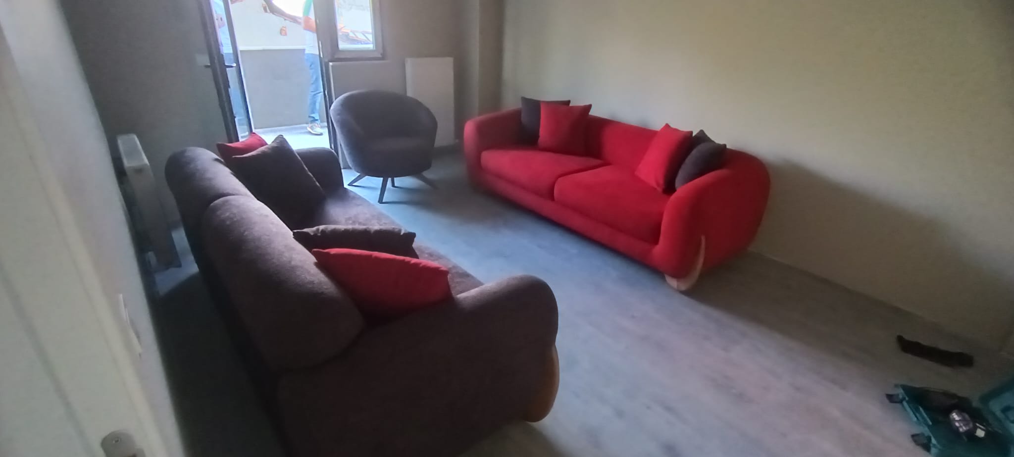 A modern living room set from Serkan Örnek - Istanbul, featuring a red and brown sofa with a grey armchair, showcasing high-quality Inegol furniture.