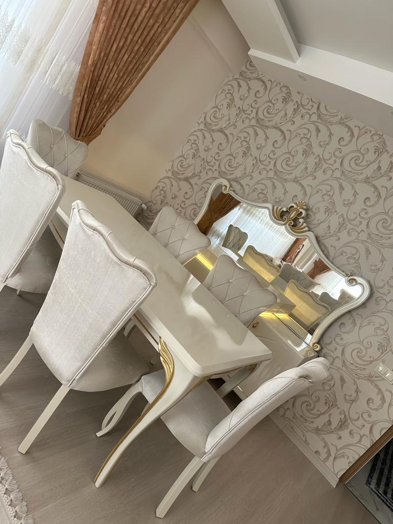 Talat Bas - Niğde dining set featuring a glossy white table and gold-detailed carved chairs, exuding elegance. Quality from inegol mobilya.