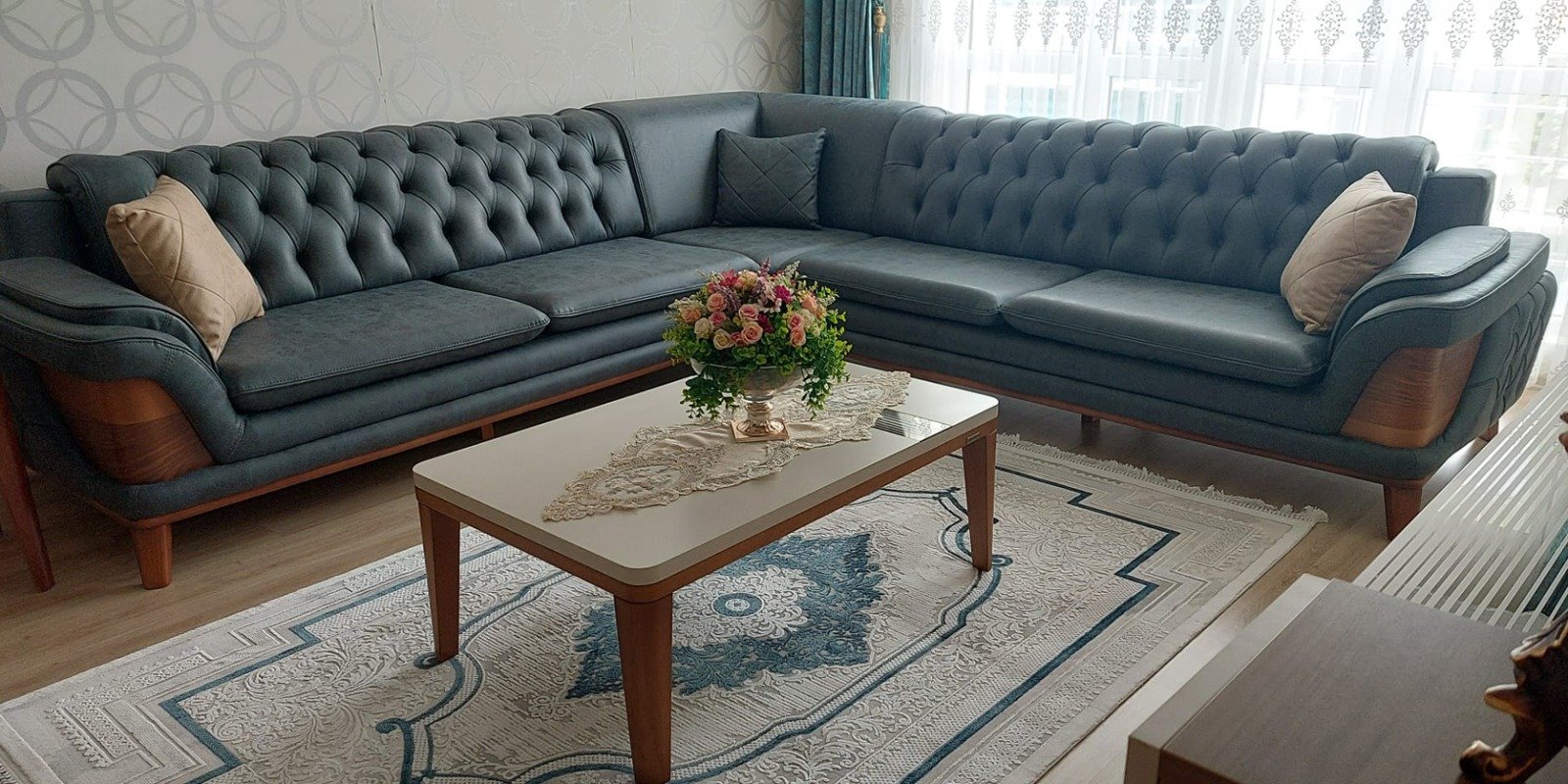 Modern gray chesterfield corner sofa set with elegant wooden details and comfortable design, perfect for any living room.