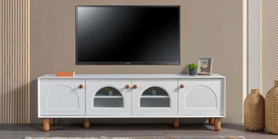 Modern beyaz Zümrüt Tv Ünitesi, ahşap ayakları ve kavisli kapak detaylarıyla dikkat çekiyor. Ev dekorasyonunuz için şık İnegöl mobilya modelleri arasında.