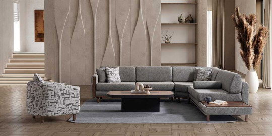 Modern tasarımlı gri köşe koltuk takımı, desenli berjer ve orta sehpa ile dekore edilmiş, ferah bir salon köşesi. Kaliteli inegol mobilya örneği.