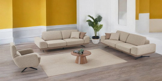 Modern bej Vogue Koltuk Takımı, ahşap zeminli, sarı duvarlı şık bir salonda. Konforlu berjer ve orta sehpa ile kaliteli bir İnegöl mobilyası.