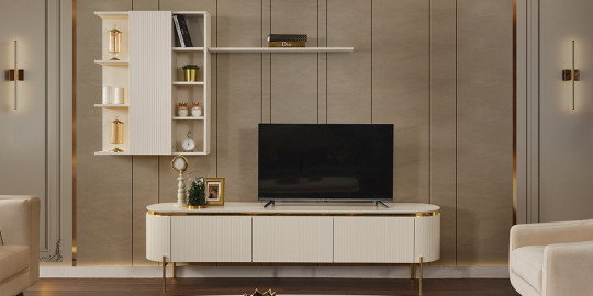Modern ve lüks bir salonda, altın detaylı, krem renkli Tesla Tv Ünitesi ve uyumlu duvar raf sistemi. Zarif İnegöl mobilya modelleri arasında öne çıkan bir tasarım.