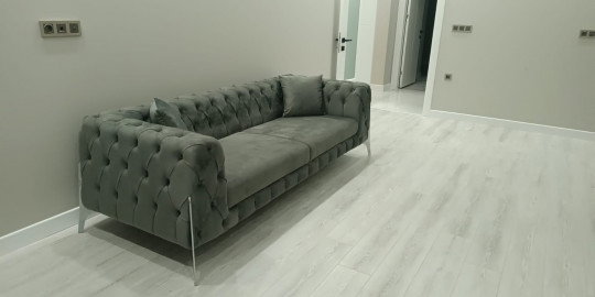 Şık gri kadife chesterfield kanepe, kapitone detayları ve metal ayaklarıyla modern bir Bursa mobilya seçeneği sunar.